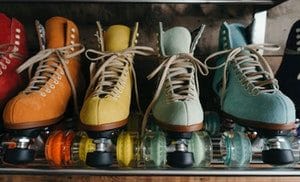 Row of colorful quad roller skates on shelf