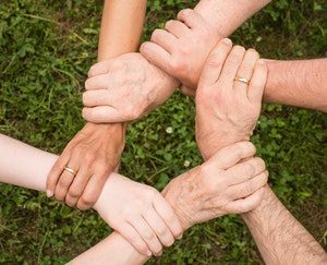 Overhead shot of clasped hands in a circle 