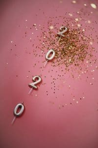 2020 candles on Millennial pink background with gold confetti