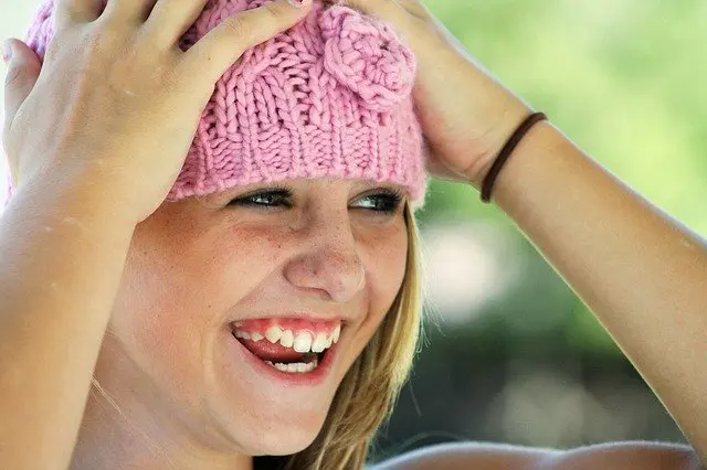 Young teen in pink hat laughing