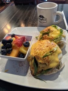 Eggs benedict with fruit and coffee